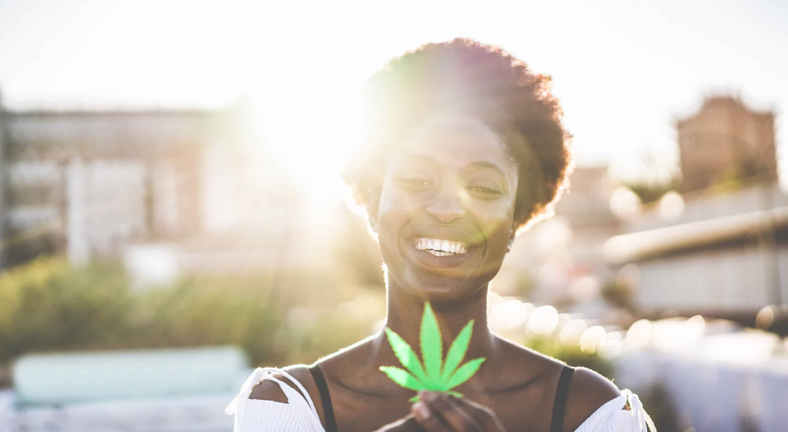 Young black girl holding marijuana leaf