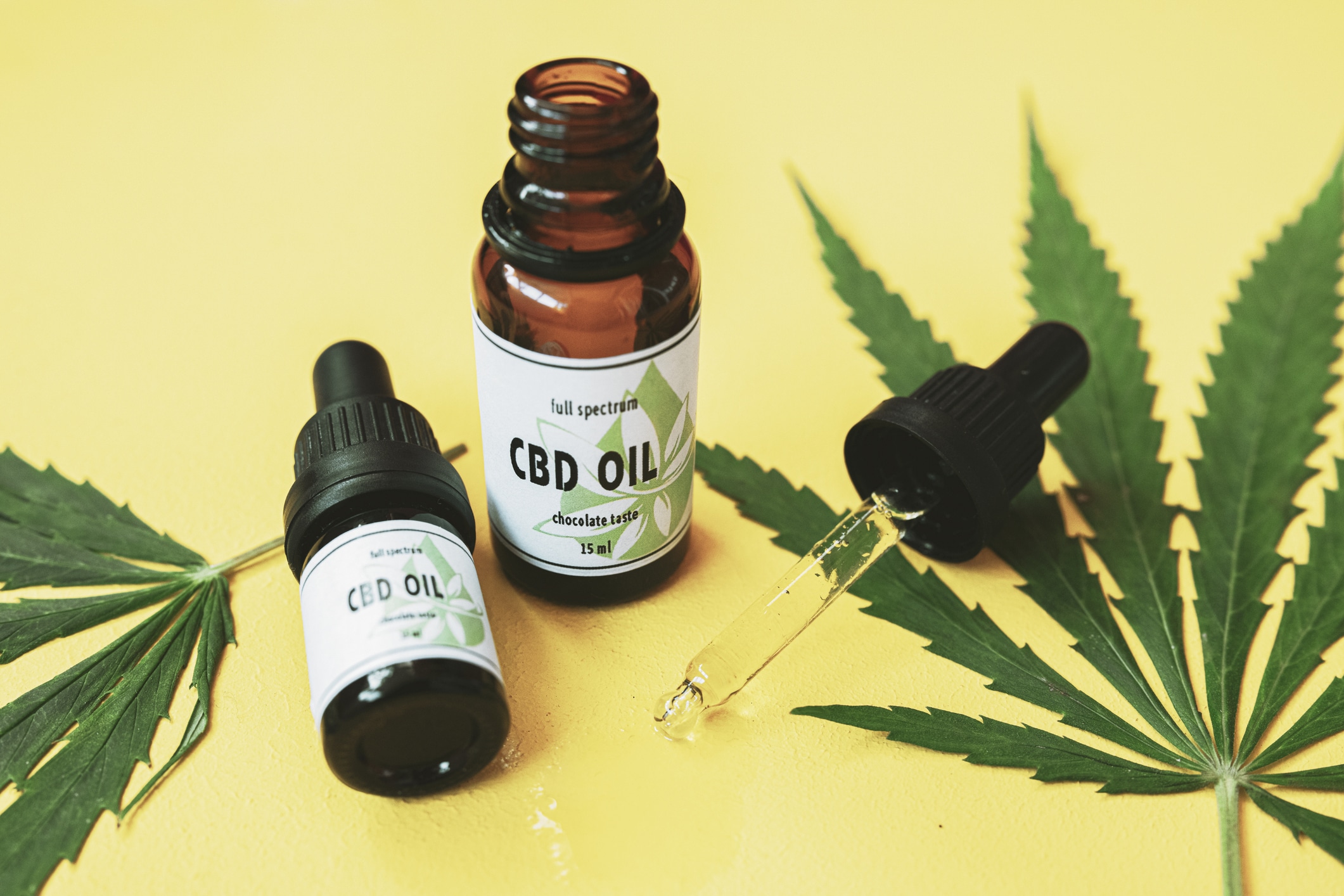 CBD oil, cannabis oil on a yellow background.