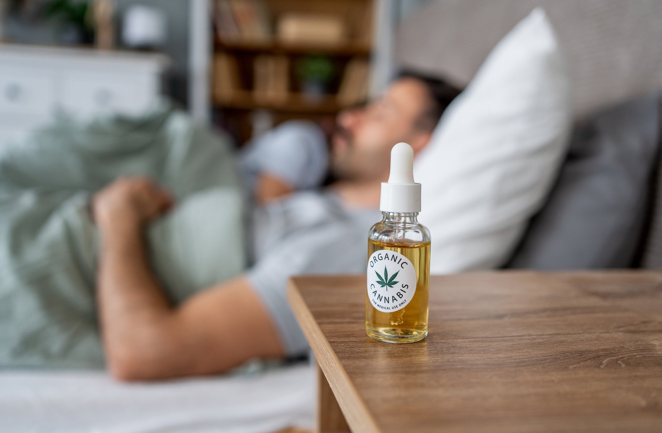 Organic cannabis oil helping a man sleep peacefully in bed
