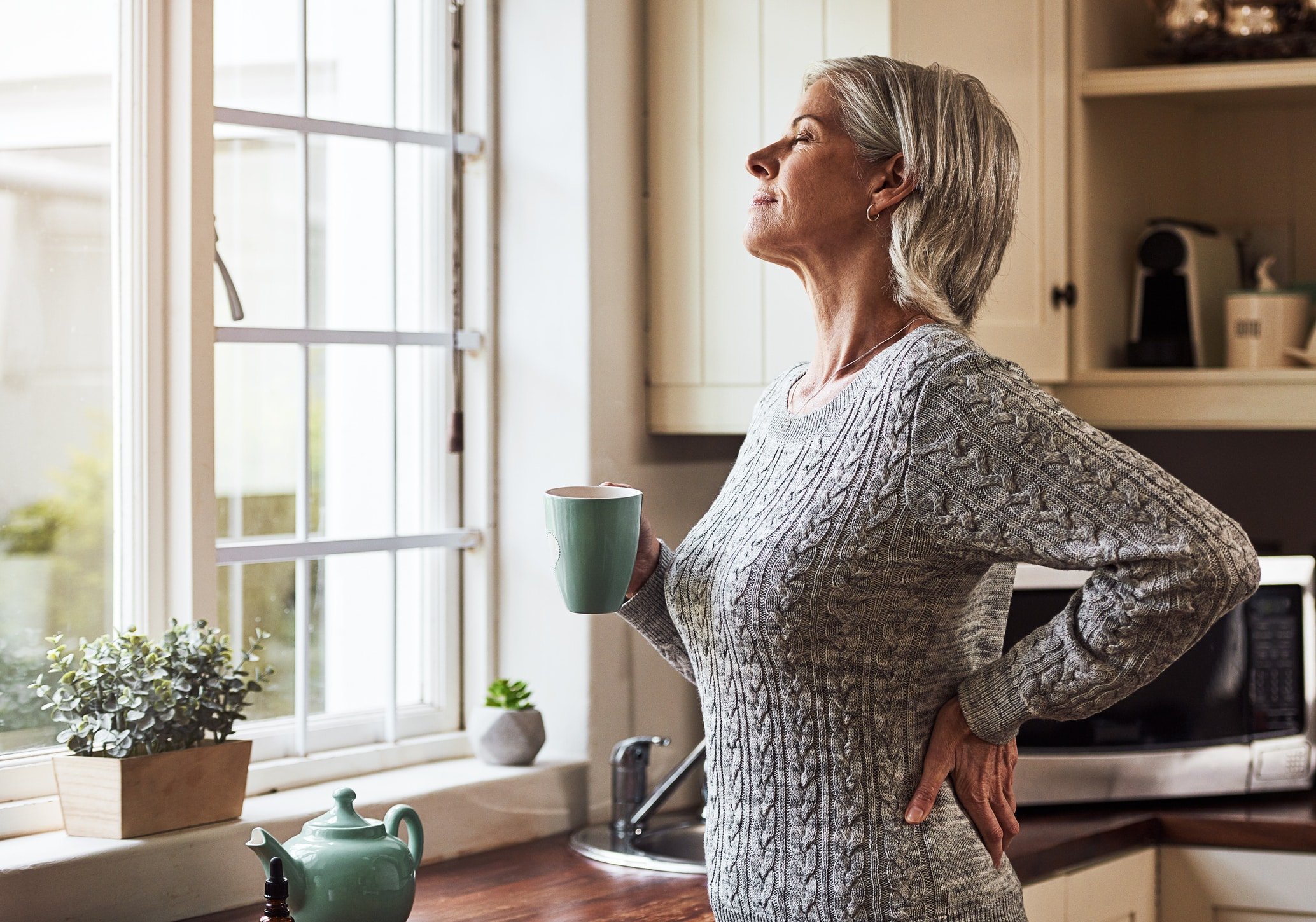 relaxed senior woman preparing a cup of tea with CBD oil