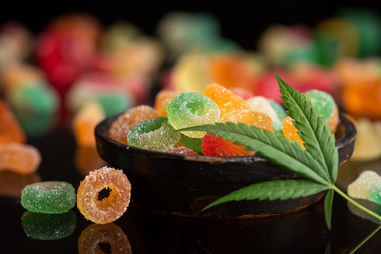 Colored candy gelatin in a black bowl with marijuana leaves