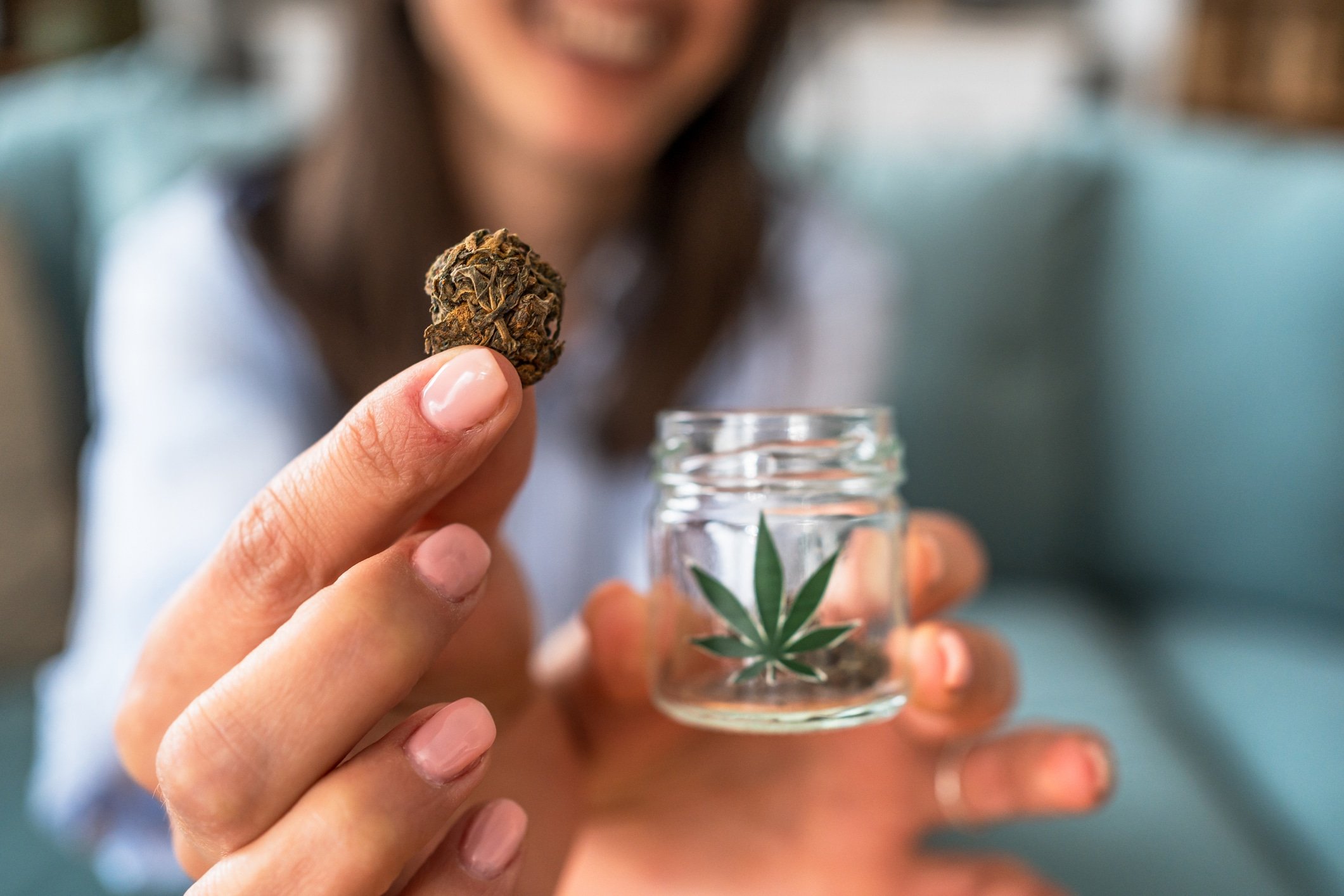 Woman holding medical marijuana bud and jar