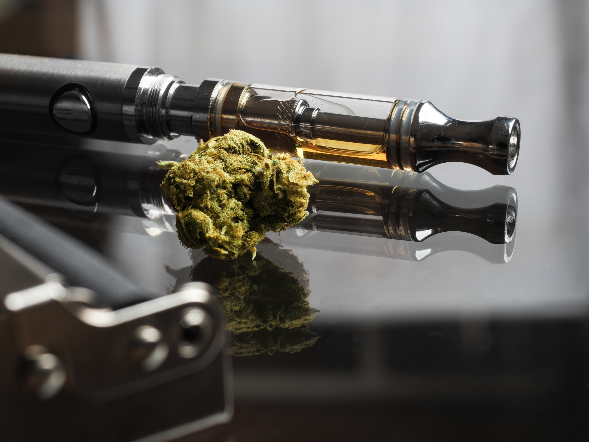 Close-up shot of real cannabis or weed with cannabis oil in a cartridge of a vape pen.
