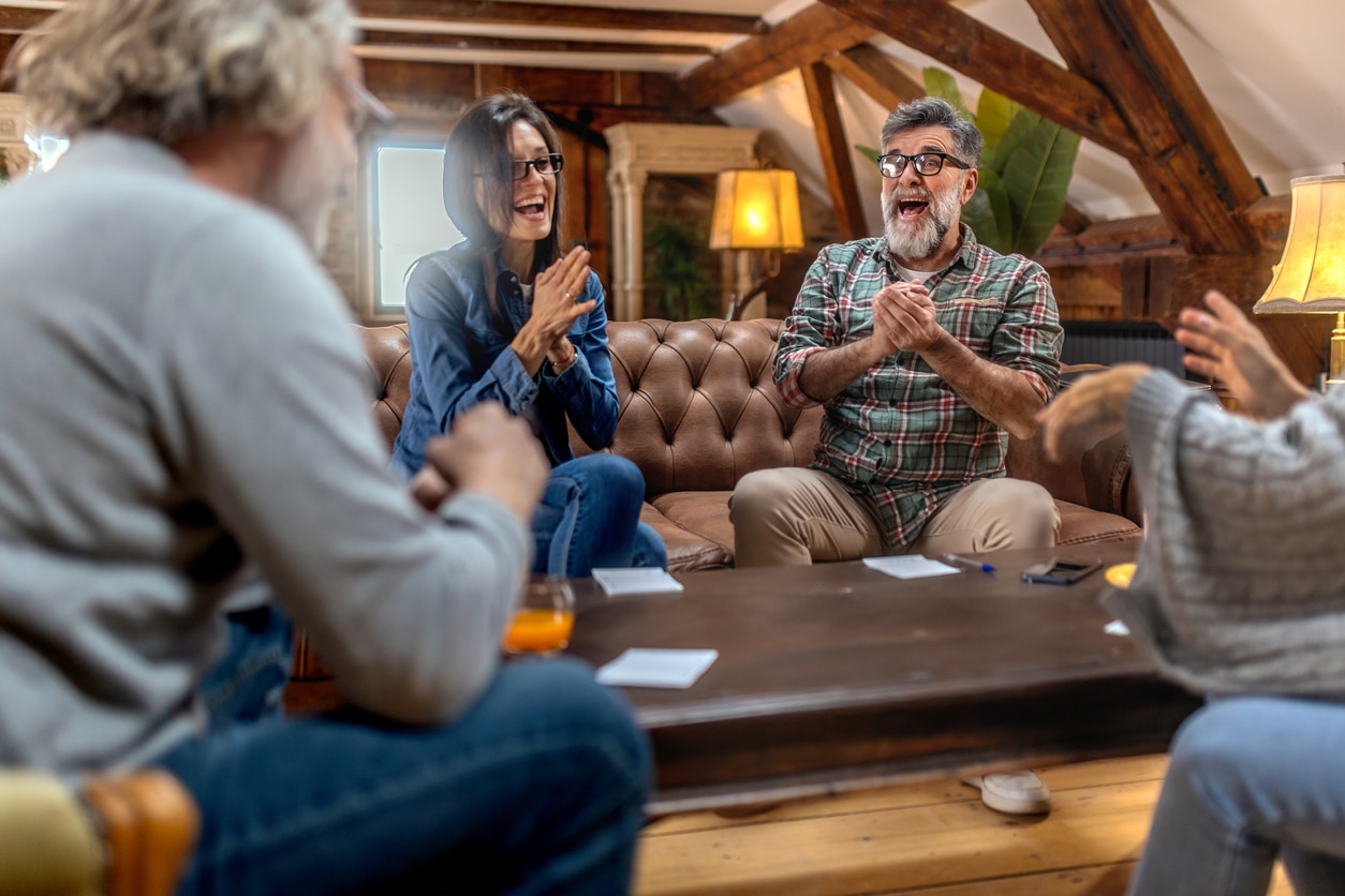 Group of happy seniors having fun while playing family  game at home.