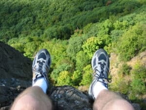 Sitting on the edge of a cliff looking down at the treetops, on Mt. Tom in Holyoke, MA.