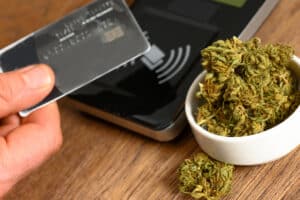 Paying by credit card for marijuana at a cannabis dispensary. Purchasing legal recreation drugs. Medical marijuana at a clinic.